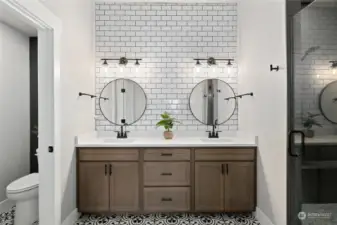 Double vanity, subway tile to the ceiling, private toilet closet and separate walk in shower.