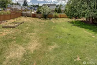 Spacious backyard with garden beds.