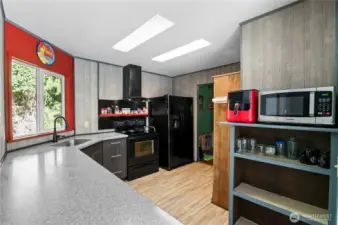 Open kitchen with newer soft close cabinets, undermount sink and updated counter top.