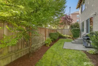 Level partially fenced yard with patio