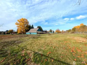 View from the corner of the lot - looking at the 3,600 sqft barn, 2,000+ sqft home, detached garage w/potential ADU & outbuilding.