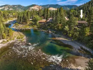 Stunning aerial of the Wenatchee River showcasing clear waters, natural shoreline, and a picturesque mountain backdrop in this highly sought-after riverfront setting.
