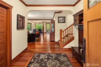 Welcoming foyer with rich hardwood floors and detailed millwork, creating a warm transition into the main living spaces.