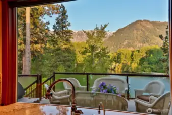 Kitchen window perfectly frames mountain and river views, bringing natural beauty right into the heart of the home.