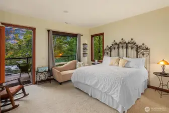 Primary suite retreat with private deck access and tranquil river views, offering a peaceful setting to relax and unwind.