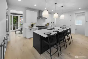 The chef’s kitchen is anchored by a large island with seating, blending crisp cabinetry, generous prep space, and effortless flow to the surrounding living areas.