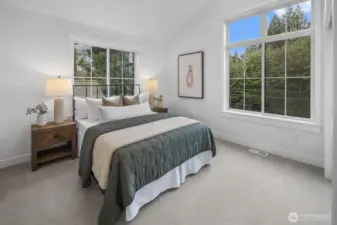 A second secondary bedroom feels equally inviting, with large windows and a calm, airy atmosphere that works beautifully for guests or everyday living.