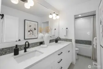 The full bath serving the secondary bedrooms features a dual-sink vanity, clean-lined finishes, and a layout designed for easy daily function.