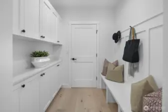 Thoughtfully designed mud room with built-in storage and bench seating creates an organized everyday entry point from the garage level.