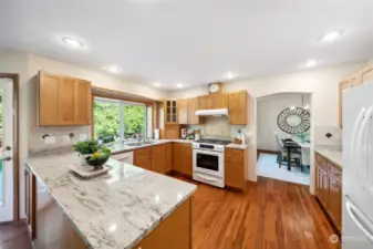 The beautifully updated kitchen boasts sleek granite countertops, abundant cabinetry and counter space, and a warm, inviting ambiance.