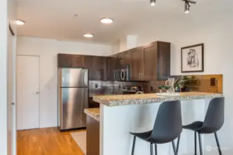 Updated kitchen with granite counter top,  stainless appliances, and bar seating.