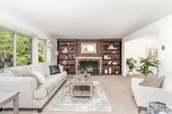Living room has bay window, built-in bookcases and fireplace