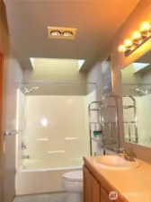 OPENING INTO THE PRIMARY ATTACHED BATH THAT HAS A SKYLIGHT OVER THE TUB/SHOWER COMBINATION!