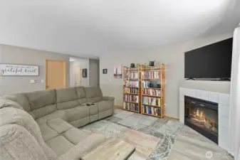 The living room is warm and inviting, featuring large windows that flood the space with natural light and a cozy gas fireplace for those chilly Northwest evenings.