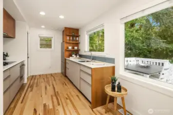 Modern kitchen overlooking deck + backyard.