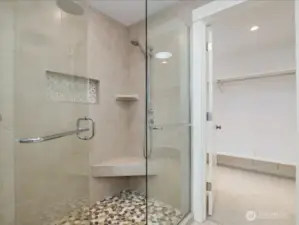 Double shower with designer tile and stone inset floors.