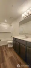 Main bathroom upstairs with LVP and quartz counters.