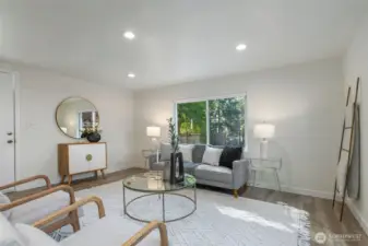 Large picture window showcases oversized front yard with mature landscaping.