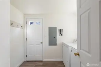 Full sized mudroom/utility space with access to the private backyard.