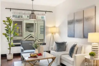 Living room with fireplace and large window overlooking the community.