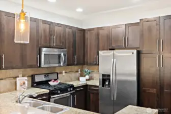 Close-up of stainless steel appliance package including gas range and built-in microwave.