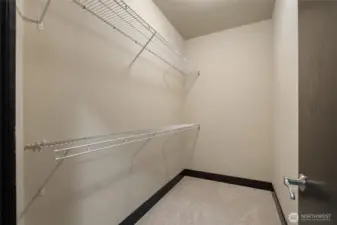 Walk-in closet with built-in shelving system for organized storage.