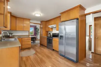Kitchen with view into dining room and stairs down to front door.