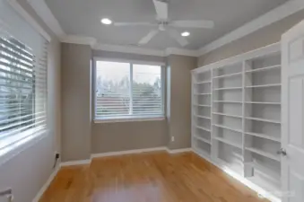 Open den with two large windows overlooking private backyard.