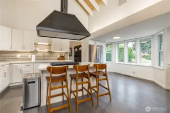 Counter seating and breakfast nook next to a bay of windows
