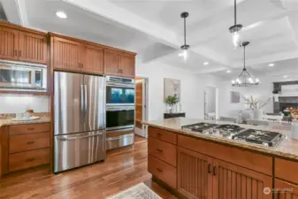 Stainless appliances featuring a 5-burner Miele propane cooktop, Frigidaire double wall ovens plus warming drawer, Miele dishwasher. There's also a large, walk-in pantry.