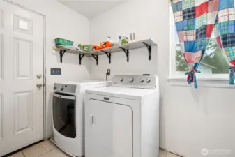 Bright and practical laundry space featuring a door that opens right to the backyard.