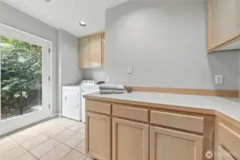 The spacious laundry room features tile floors, a large counter and cabinet area as well as a shower. Great for rinsing off after a day on the lake or for a guest that is staying in the main floor den/office.