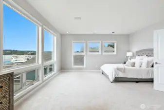 The sumptuous primary bedroom suite is extremely large and boasts wall to ceiling windows that capture the serene views of Lake Washington from every angle.