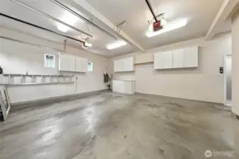 This attached, large, two car garage boasts high ceilings, storage cabinets and a drop-down attic space for loads of additional storage options.