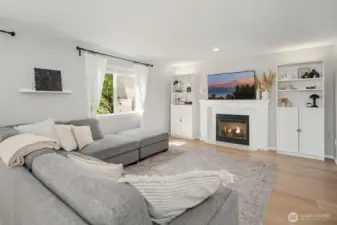 Family Room has a cozy gas fireplace focal point and cabinets added around fireplace for extra display