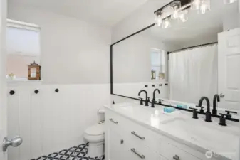 Upstairs 5-piece bathroom has a dual sink vanity with a granite countertop, updated plumbing and lighting. Tub and shower with a beadboard accent and tile flooring.