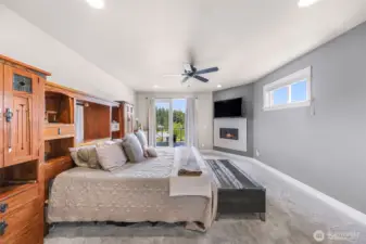 Primary bedroom with fireplace and french doors to the deck
