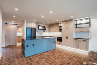 Modern kitchen counters and luxury appliances accented by automatic undercounter and undercabinet lighting. Ample kitchen storage space.