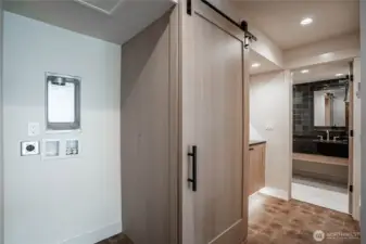 Sliding door conceals the stacking washer/dryer laundry area near the guest bathroom.