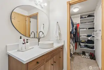 Primary bath vanity and walk in closet (door removed).