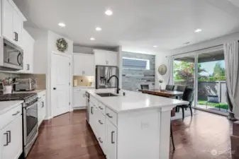 This dreamy kitchen boasts of bright white cabinets, quartz counter tops and a huge center island that grounds the kitchen.