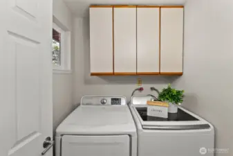 The washer and dryer stay, and you'll appreciate the ample storage space above, complete with sturdy cabinets to keep everything organized.