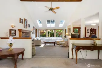 Front living room with fireplace and windows to the fully fenced yard.