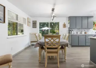 The dining area connects seamlessly to both the kitchen and living room, with a sliding door that invites the outdoors in.