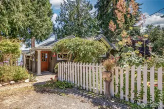 Full of storybook charm, framed by a classic white picket fence that adds warmth and lovely curb appeal.