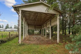 The covered RV parking shed has not been used for some time but awaits a little mowing and refreshing.