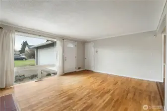 Living Room looking out large front window, front door & closet on the right