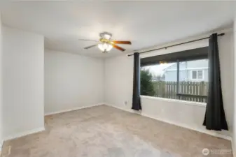 Freshly carpeted Family room with fan and large window looking out to another covered area outside