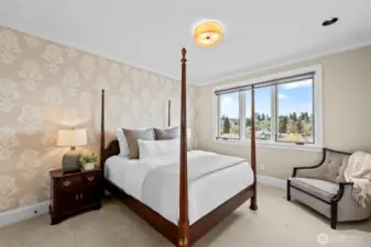 A feature wall of vibrant, high-end wallpaper transforms this secondary bedroom into a stylish retreat, adding a layer of visual depth and 'fun' to the home’s sophisticated palette.