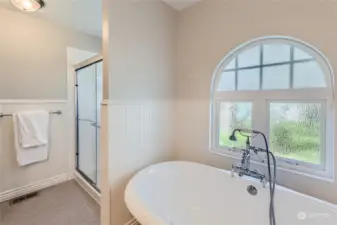 This bright spa-like bathroom has a privacy window in the shower and over the soaking tub.  New shower head.  Unique newer vintage style bathtub fixture.  Newer flooring. Newer paint.